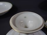 a close up of a white and gold cup and saucer on a table