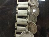 a silver bracelet that has a bunch of coins on it