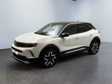Le SUV blanc est garé dans une pièce au sol noir.