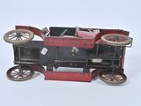 a small red toy car with wheels on a white surface