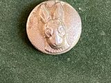 un gros plan d'un bouton en métal orné d'une tête de chien