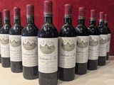 six bouteilles de vin rouge alignées sur une table en bois