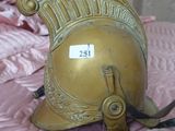 un casque doré posé sur un lit recouvert d'une couette rose