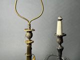 pair of antique brass candlesticks and a candle holder on a grey background