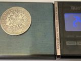 a silver coin sitting on top of an electronic scale