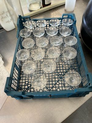many empty wine glasses in a blue crate