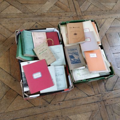 boxes filled with books sitting on top of a wooden floor