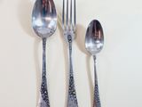 three silver spoons and two silver spoons on a white table