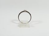 a close up of a diamond ring on a white surface