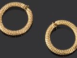 deux paires de boucles d'oreilles créoles en or posées sur un fond noir