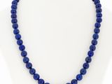 a blue beaded necklace on a mannequin neck