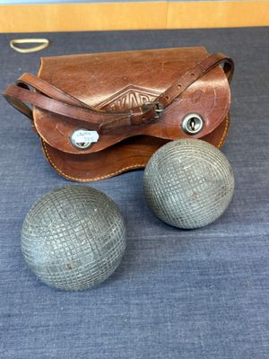 two balls and a leather case on the floor