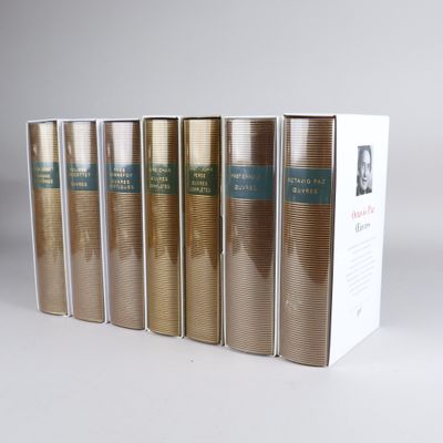 six books are lined up in a row in front of a white box