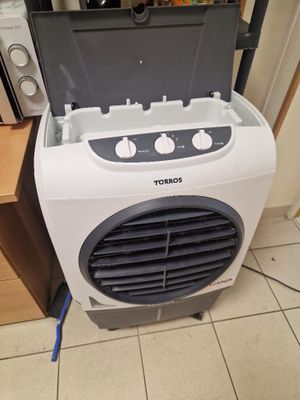 a small air conditioner sitting on the floor next to a microwave