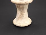 an old white vase sitting on top of a black table