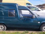 a blue van parked in a parking lot next to a white car