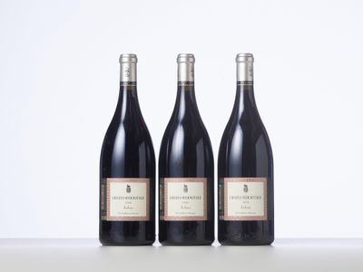 trois bouteilles de vin posées sur une table l'une à côté de l'autre