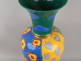 a colorful vase that is sitting on a white surface
