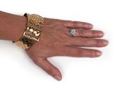 someone wearing a gold bracelet and a diamond ring on their hand