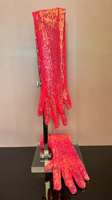 une paire de gants roses posée sur une table noire