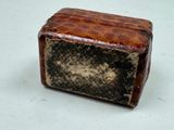 a small brown and black box on a white surface