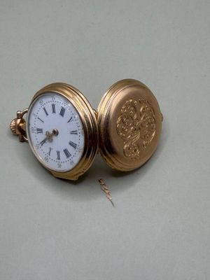 une montre de poche en or avec des chiffres romains
