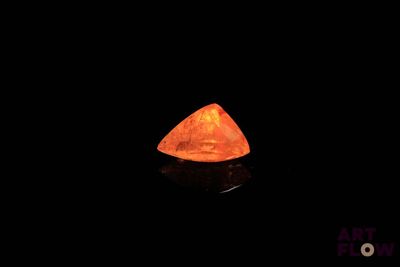 un losange orange dans l'obscurité, sur fond noir
