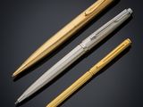 three different types of pens on a black background