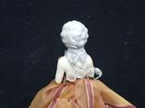 a figurine of a woman in a yellow dress