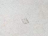 a close up picture of a white plate with a small diamond on it