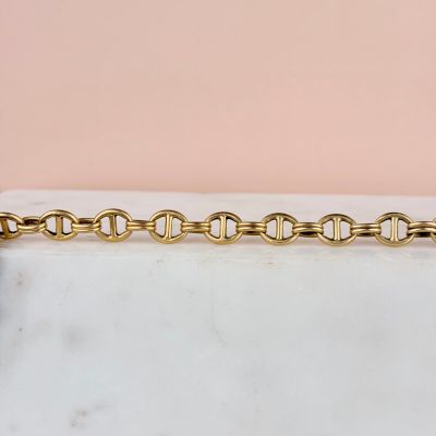 a close up of a gold chain on a white surface