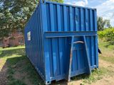 a blue container sitting in the middle of a field