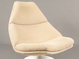 une image représentant une chaise beige avec un piètement blanc sur fond gris