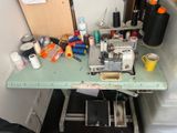 une machine à coudre posée sur une table verte