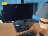 un bureau sur lequel se trouvent un ordinateur, un clavier, une souris et une lampe