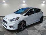 a white ford fiesta parked on a checkered floor in a garage