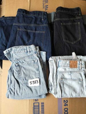 Plusieurs paires de jeans sont empilées sur une boîte en carton