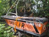 an orange and black boat that is sitting in the grass