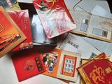 une boîte remplie de cartes rouges et dorées posée sur une table