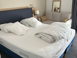 un lit avec des draps et des oreillers blancs dans une chambre d'hôtel