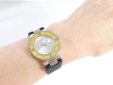wrist of a woman with a yellow and black watch on her wrist