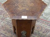 une petite table décorée d'un motif, posée sur un tapis