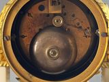 a gold and white clock that is on a stand