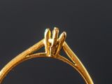 a close up of a gold ring with a diamond in the center