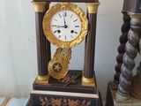 a clock that is sitting on a table next to a candle