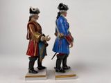 pair of figurines of two men dressed in historical clothing