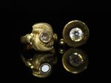 un gros plan sur une paire de boutons de manchette en or sertis de diamants