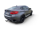 the rear end of a silver bmw x6 with a black bumper