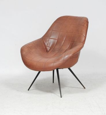 un fauteuil en cuir marron avec des pieds noirs et un piètement en métal noir