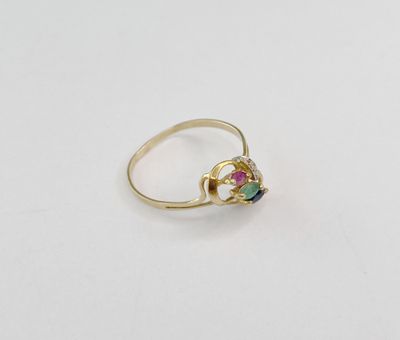 un gros plan d'une bague en or sertie d'une pierre verte, rouge et bleue